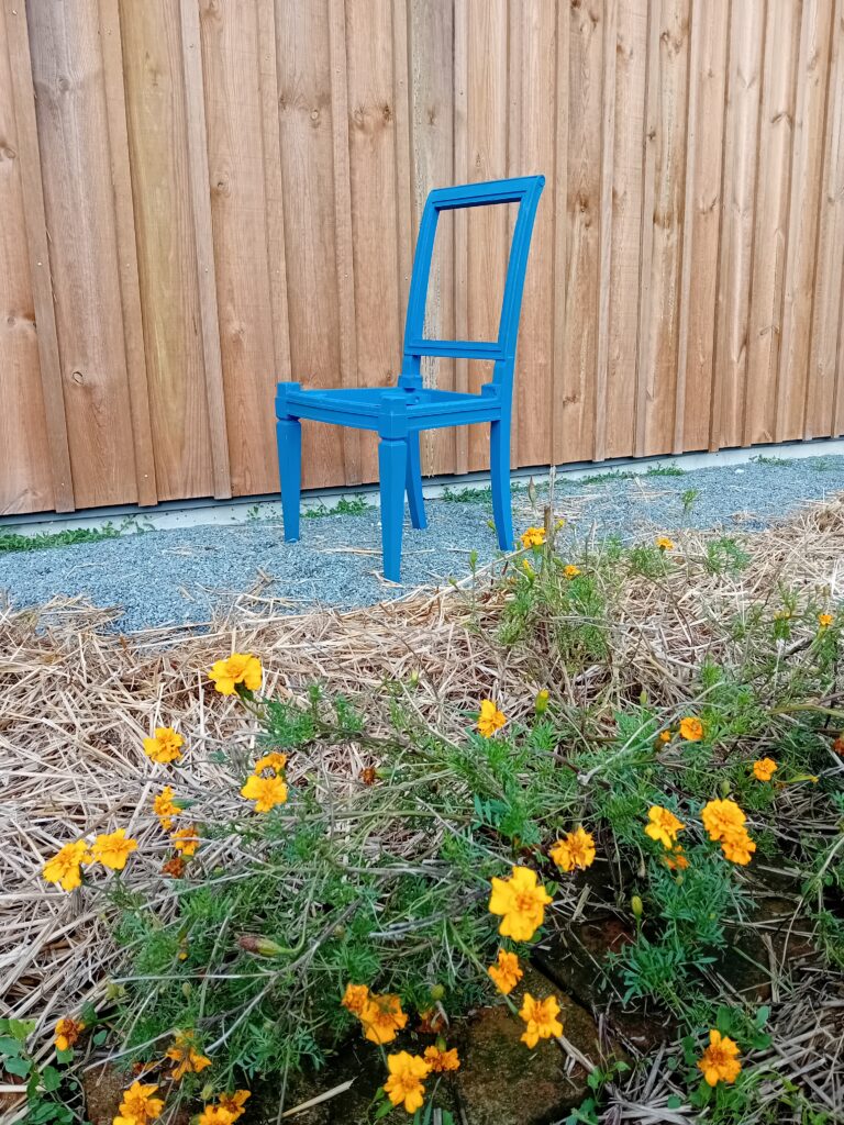 Chaise bleue devant l'atelier de tapisserie d'ameublement